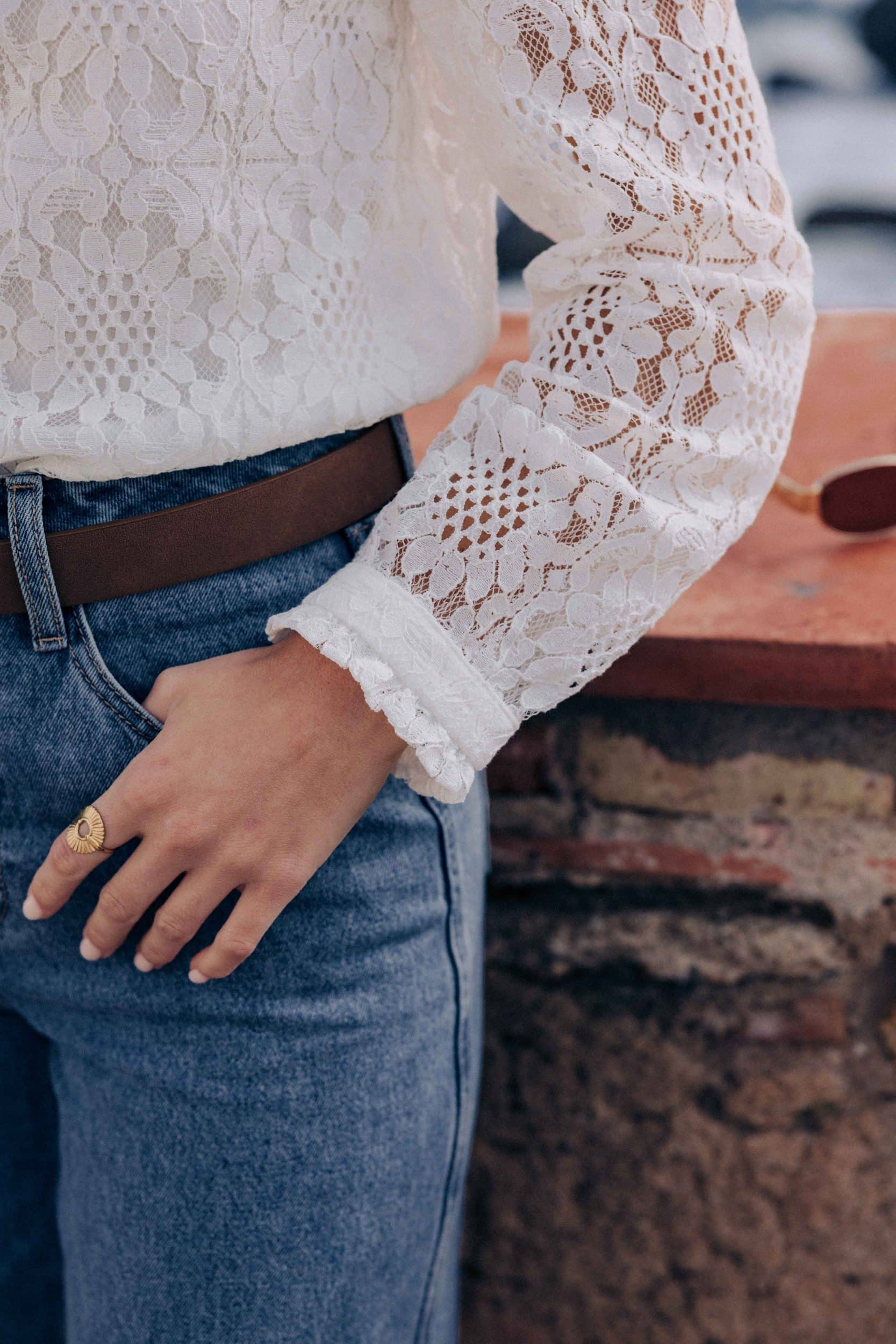 blouse-leona-blanche-sahoma-00008 Blouse Leona Sahoma blanche aux motifs floraux en dentelle, col montant à volants, manches longues, portée avec un jean bleu foncé