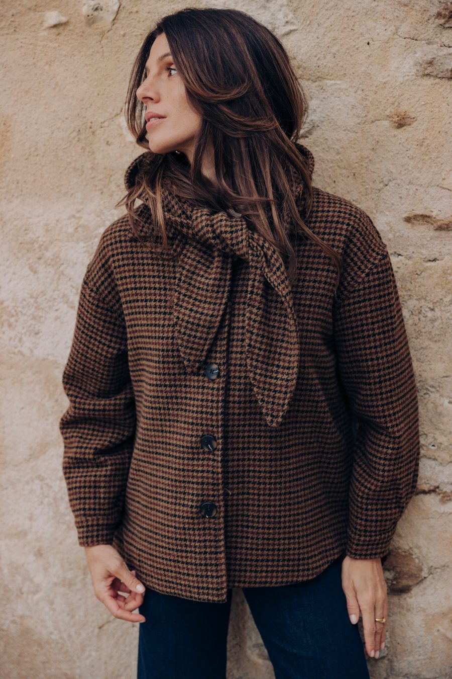 Veste Silven pied-de-poule marron portée avec capuche assortie nouée sous le menton