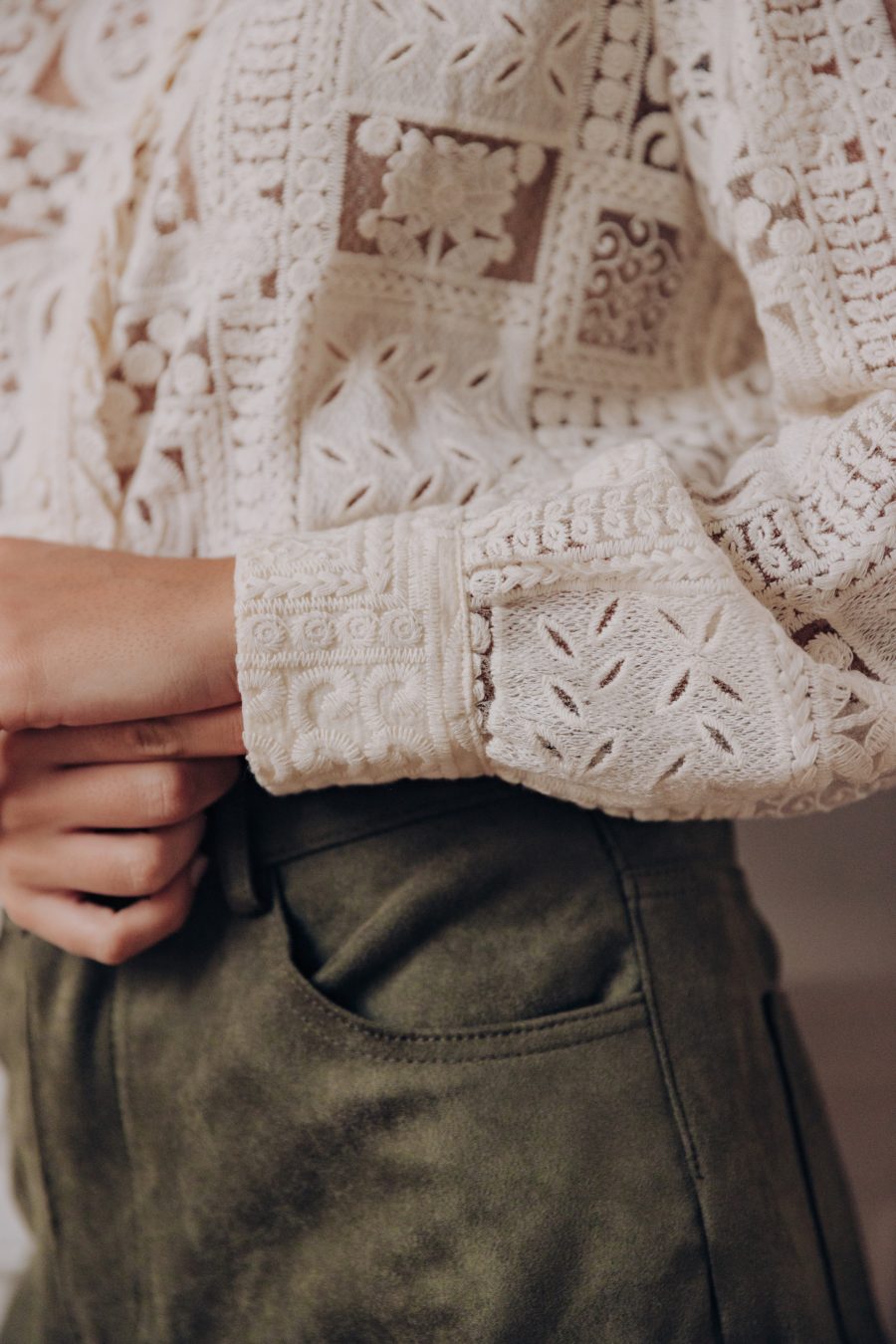Détail du poignet de la blouse Alana Sahoma semi transparente en dentelle écrue boutonnée et manches longues