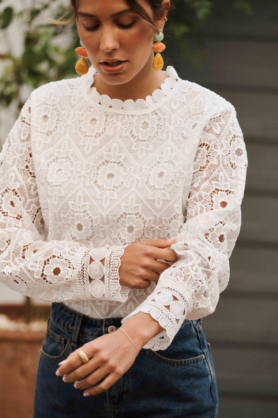 Blouse Martha Sahoma blanche en dentelle, manches longues, portée avec un jean