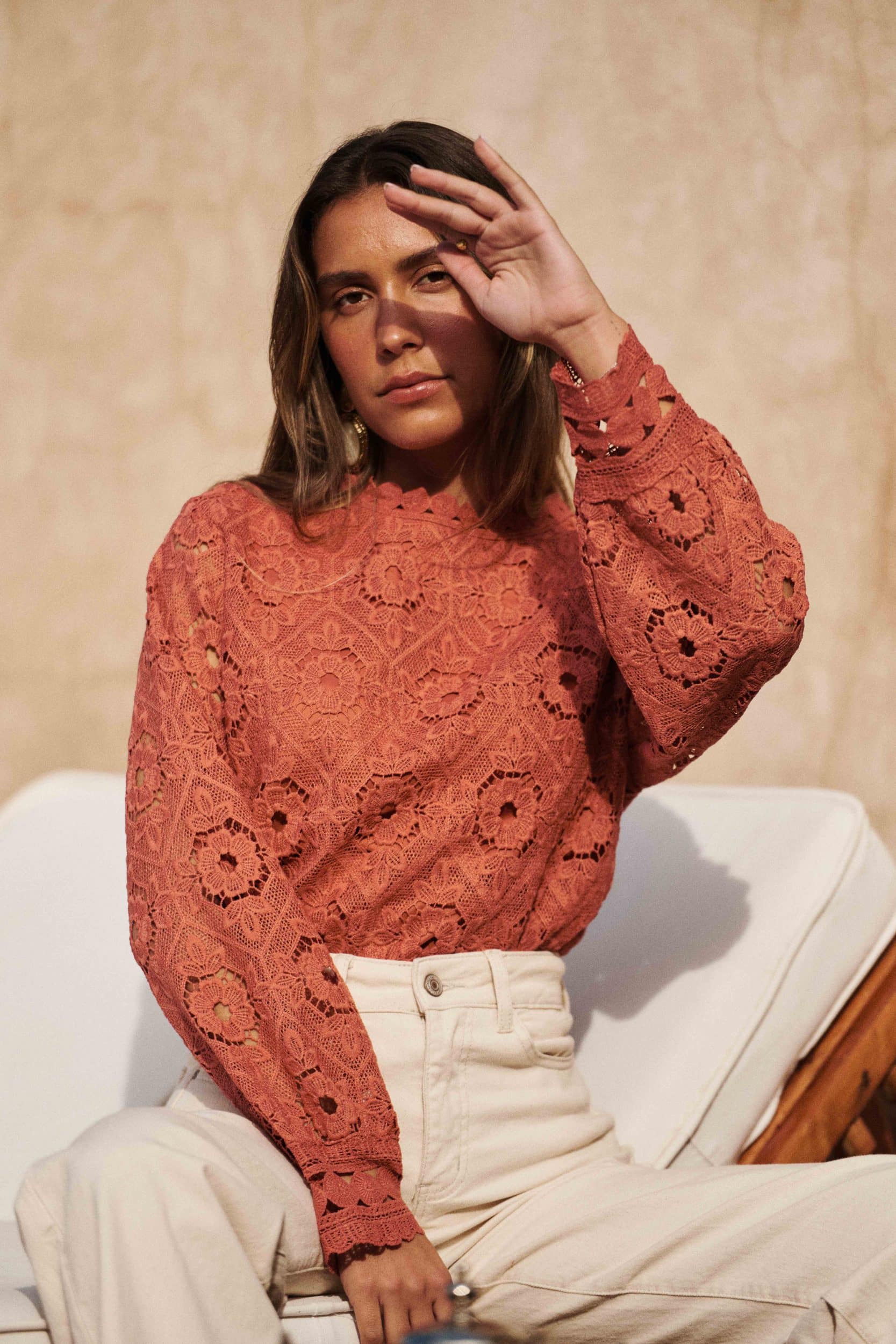 Blouse Martha Sahoma terracotta en dentelle, manches longues, portée avec un jean