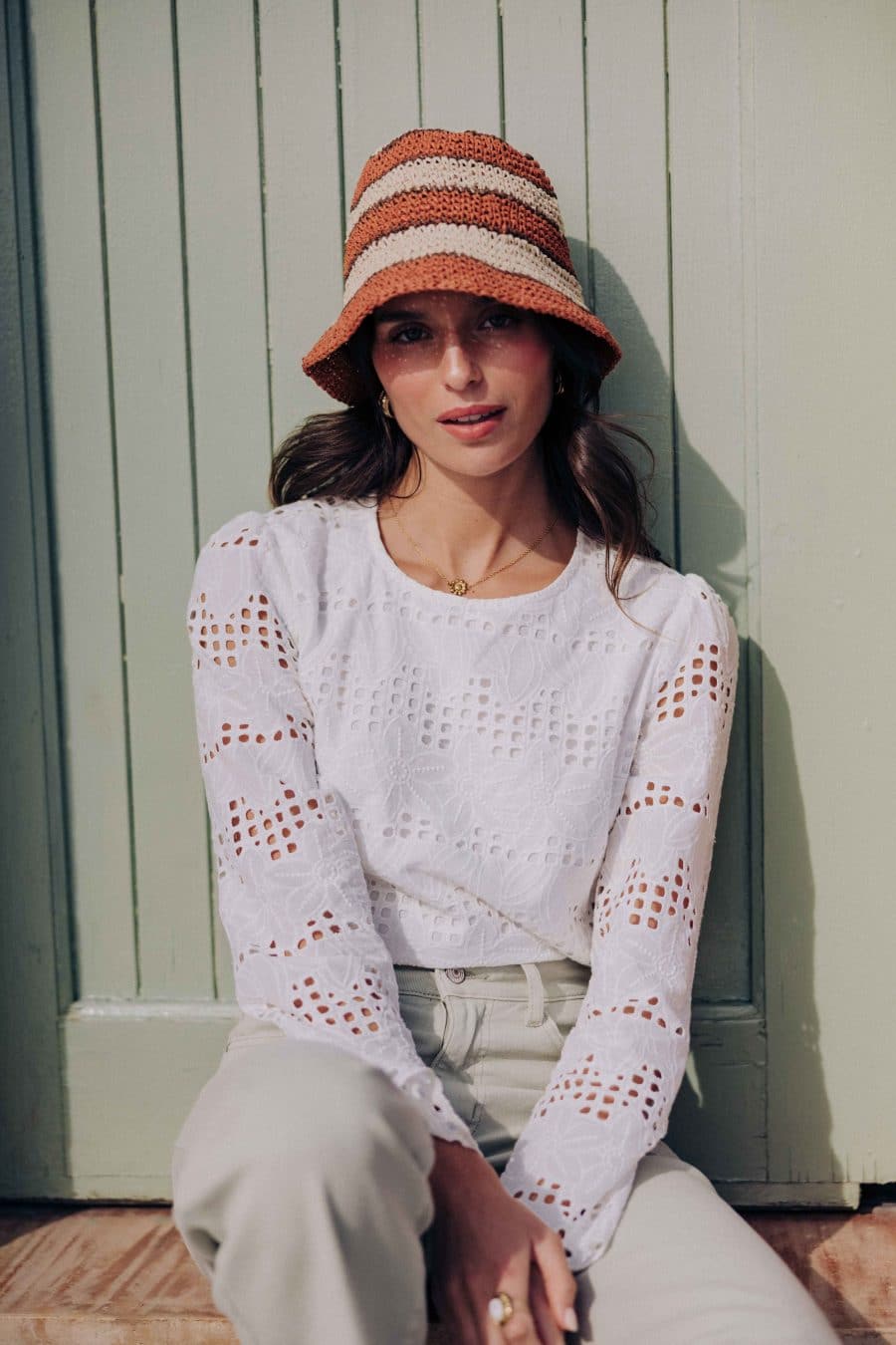 Blouse Zahara Sahoma blanche aux motifs floraux en broderie anglaise, col rond, manches longues, portée avec un jean