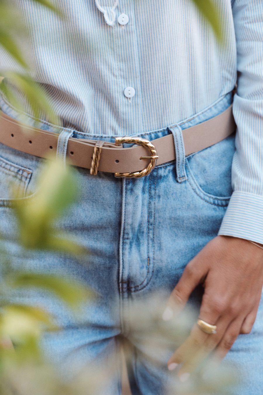 Ceinture Almira Sahoma en suédine beige, boucle dorée tressée, portée sur un jean clair