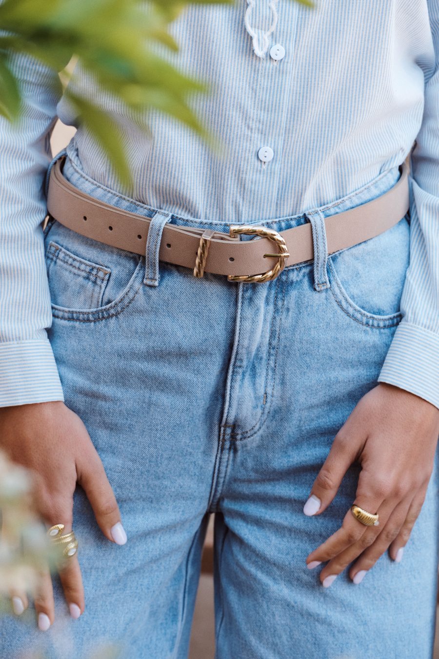 Ceinture Almira Sahoma en suédine beige, boucle dorée tressée, portée sur un jean clair