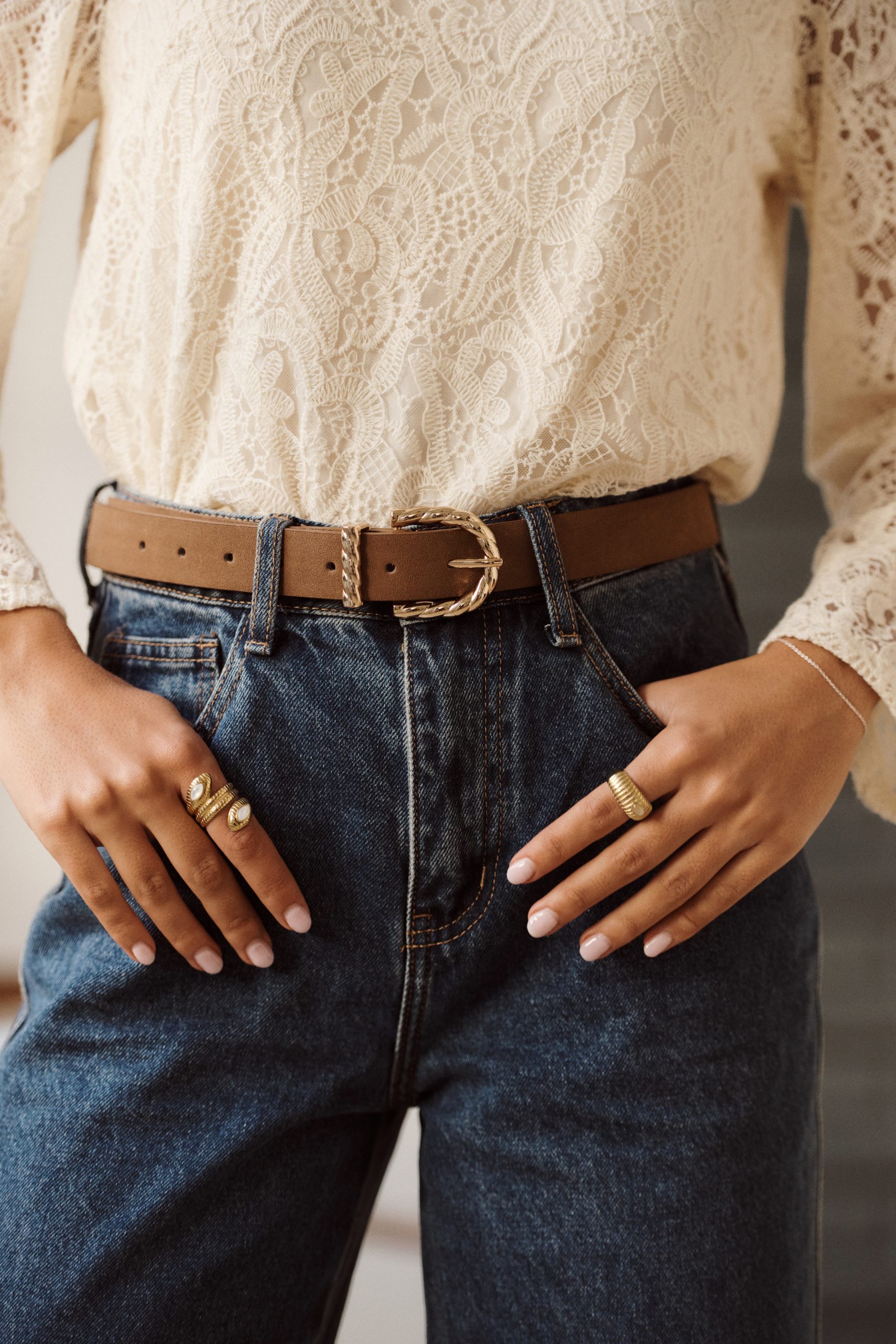 Ceinture Almira Sahoma en suédine marron clair, boucle dorée tressée, portée sur un jean foncé