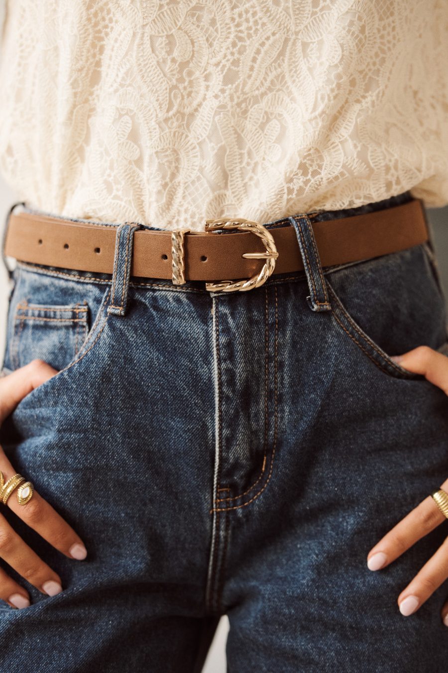 Ceinture Almira Sahoma en suédine marron clair, boucle dorée tressée, portée sur un jean foncé