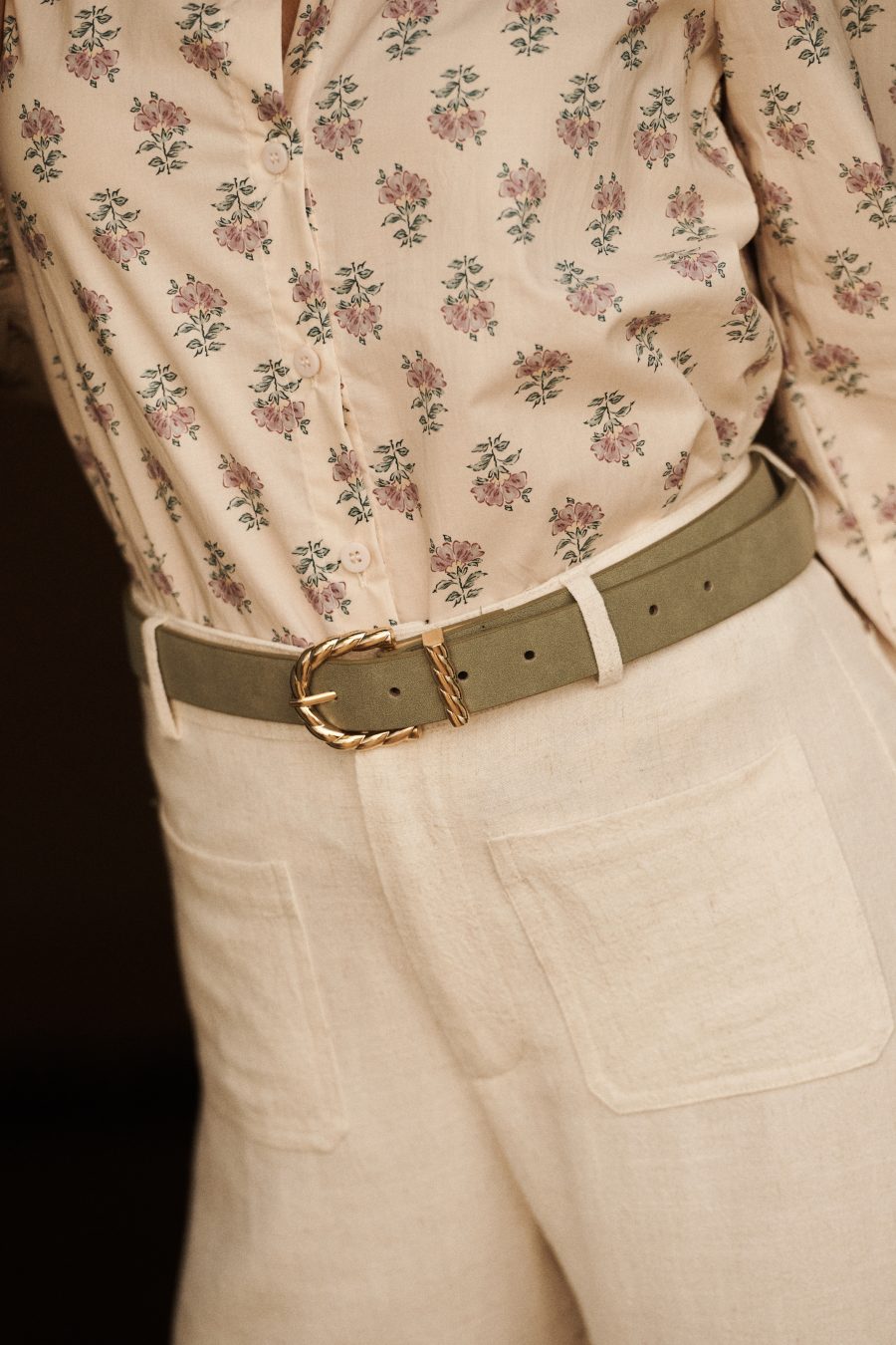 Ceinture Almira Sahoma en suédine vert clair, boucle dorée tressée, portée sur un pantalon clair