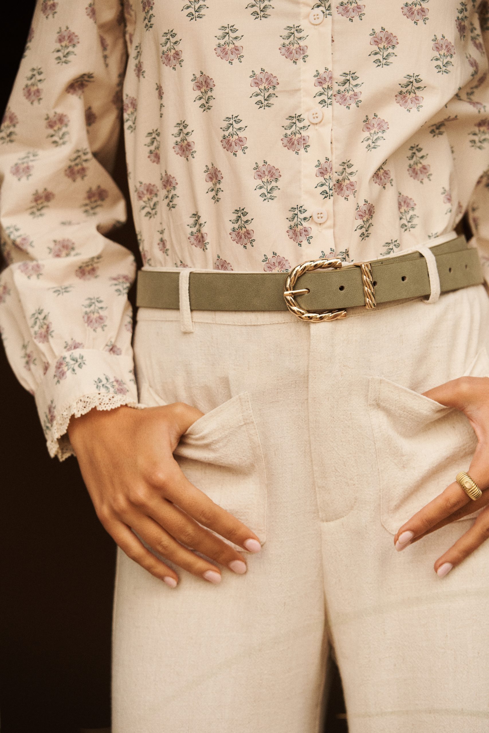 Ceinture Almira Sahoma en suédine vert clair, boucle dorée tressée, portée sur un pantalon clair