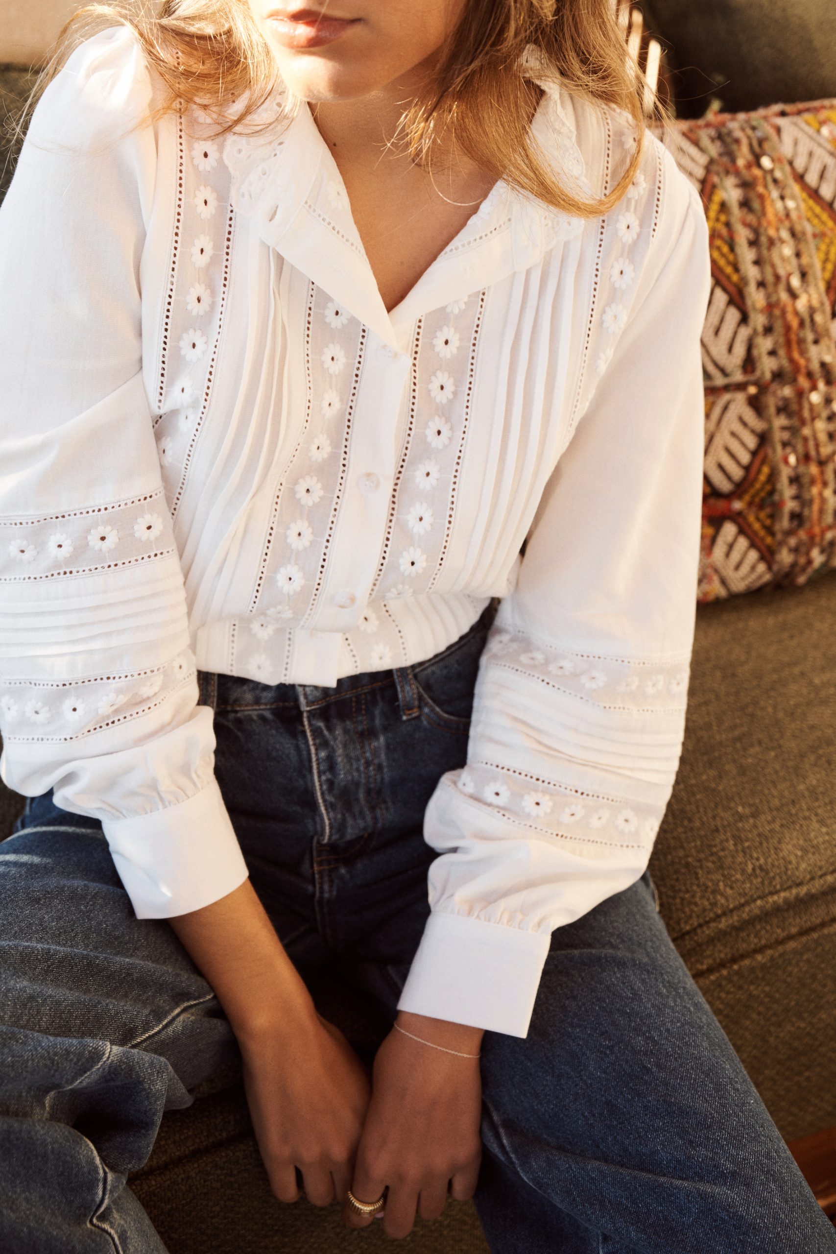 Chemise Coralie Sahoma blanche à broderie anglaise aux motifs floraux, manches longues, portée avec un jean foncé