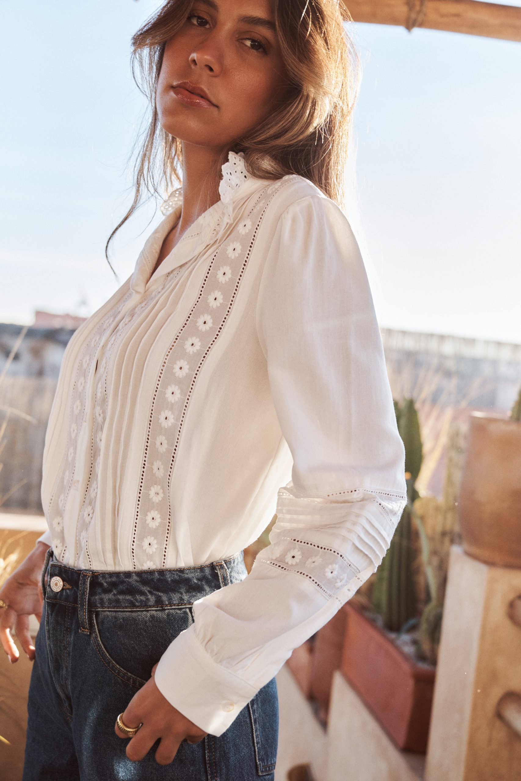 chemise-coralie-blanche-sahoma-00008 Chemise Coralie Sahoma blanche à broderie anglaise aux motifs floraux, manches longues, portée avec un jean foncé