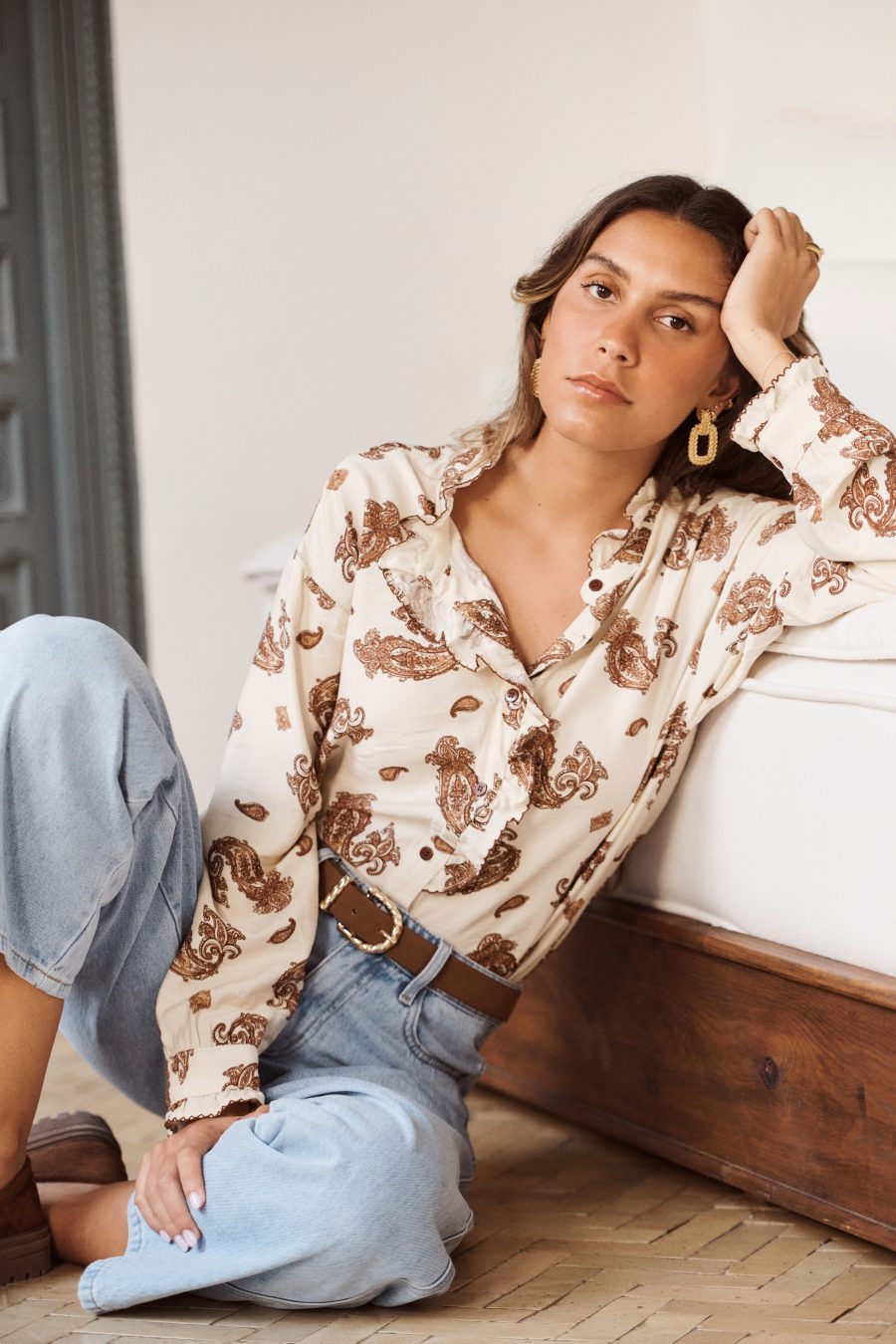 Chemise Inaé Sahoma en camaïeu marron, imprimé cachemire, col et jabot à volants, manches longues, portée avec un jean clair