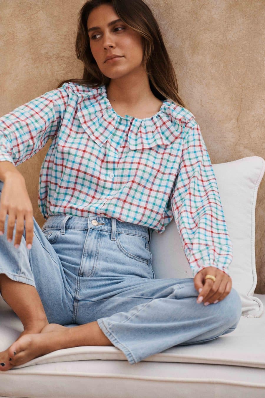 Chemise Rima Sahoma aux motifs vichy coloré, col Claudine à volants manches longues, portée avec un jean bleu clair