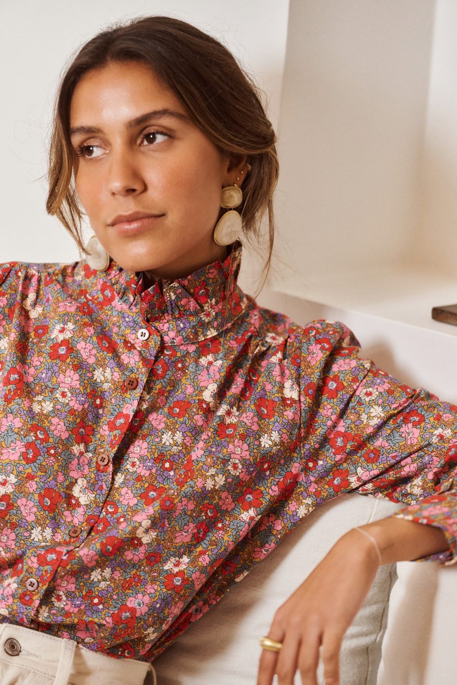 Chemise Sarena Sahoma imprimé fleuri rose, col montant à volants, manches longues, portée avec un jean clair