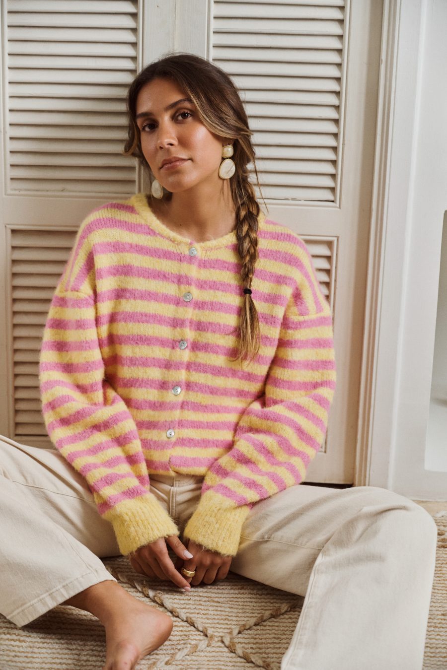 Gilet Camille Sahoma rayée rose et jaune en maille et boutonné, manches longues, portée avec un jean