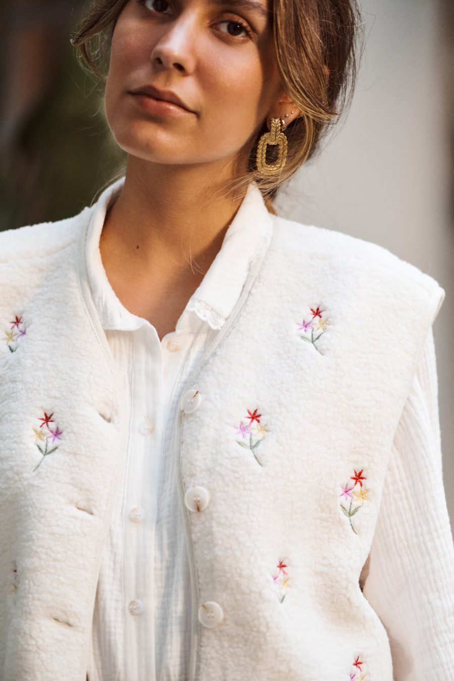 Gilet Celestine Sahoma en sherpa écru, sans manches à boutons porté avec un pantalon en lin