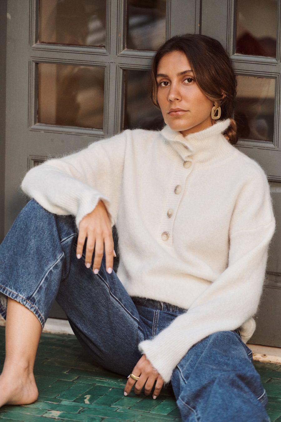 Pull Alren Sahoma écru col montant à boutons, manches longues, portée avec un jean