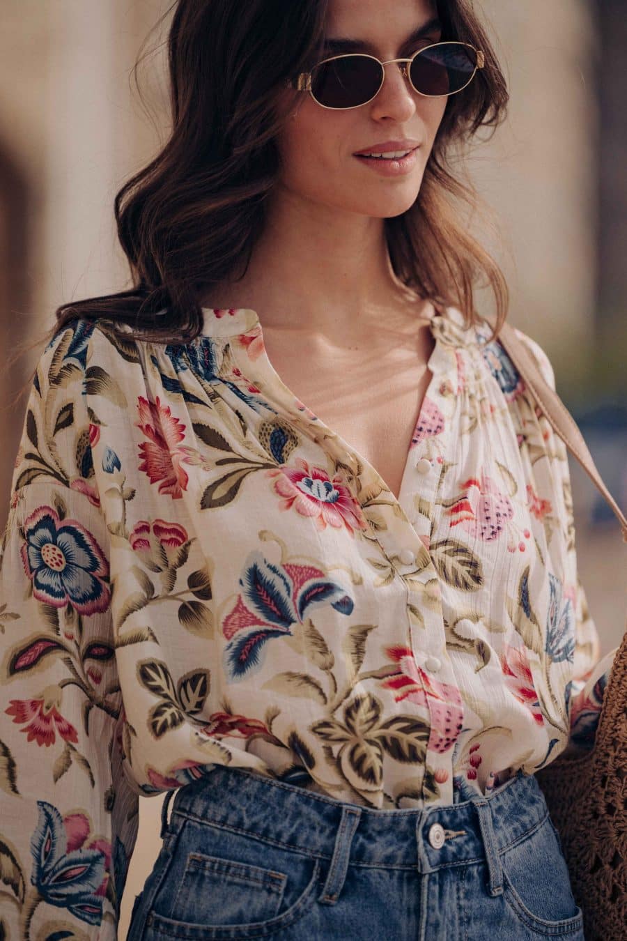 Blouse Calyne Sahoma écrue aux motifs floraux multicolore, manches longues, portée avec un jean bleu foncé