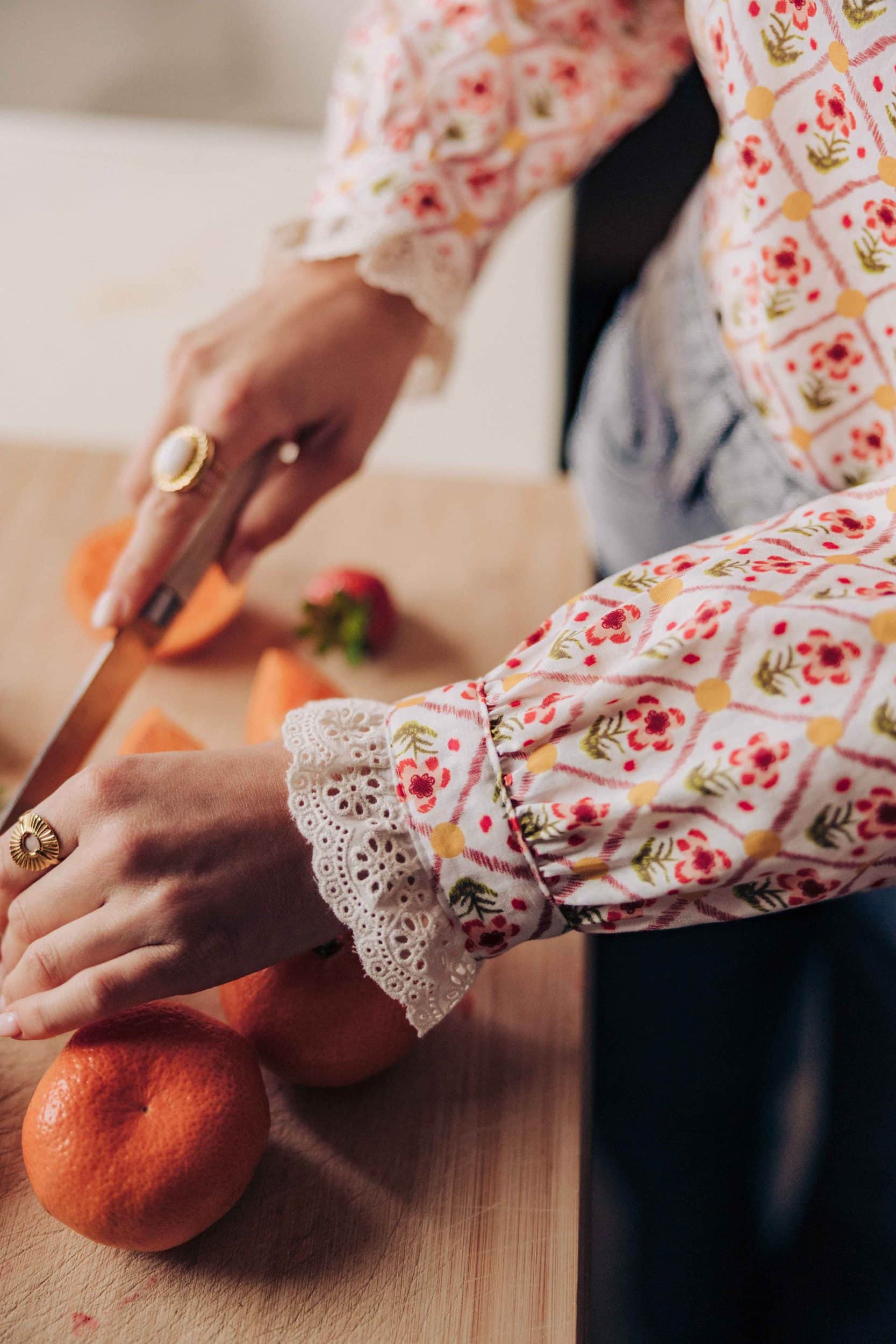Blouse Niam Sahoma écrue aux motifs floraux colorés, col montant à volants, manches longues, portée avec un jean gris clair
