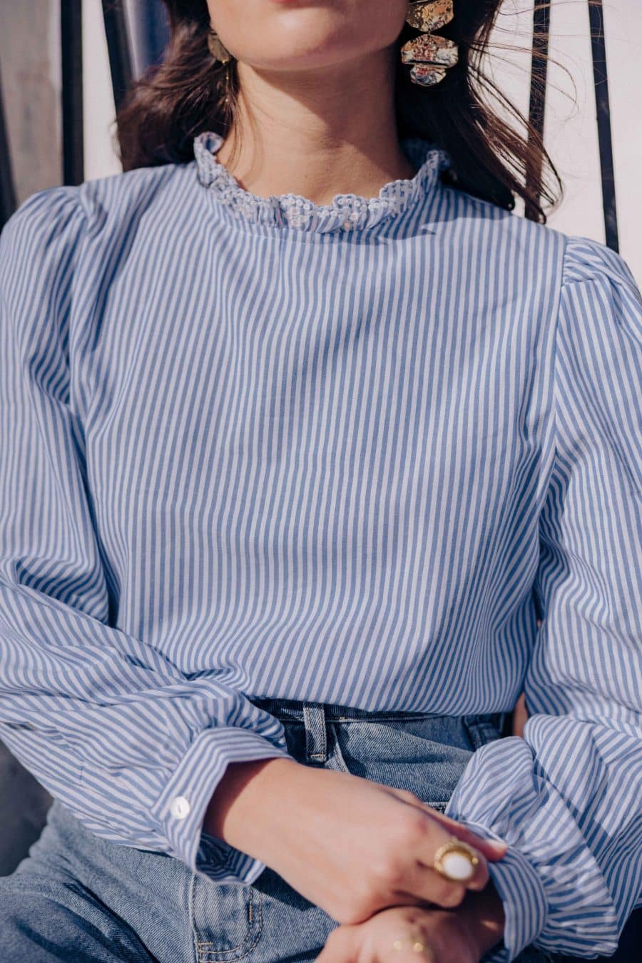 Blouse Nolane Sahoma rayée bleu et blanc, col montant à volants blanc, manches longues, portée avec un jean