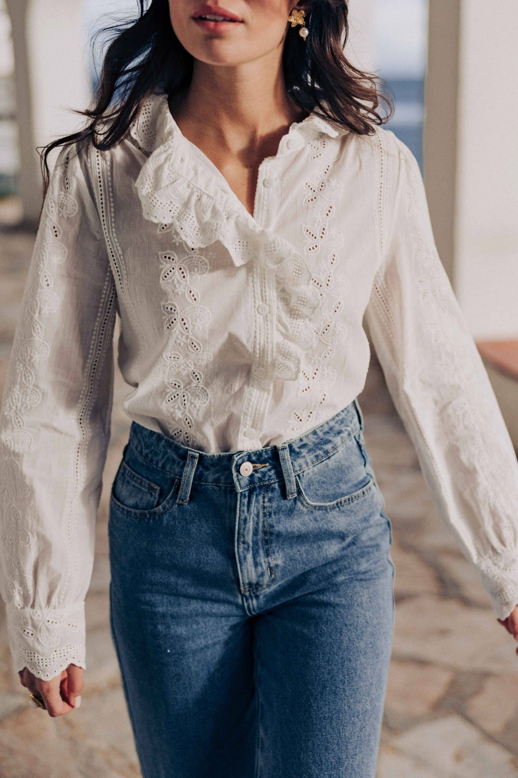 Chemise Aleia Sahoma blanche aux motifs floraux en broderie anglaise, manches longues, portée avec un jean bleu foncé