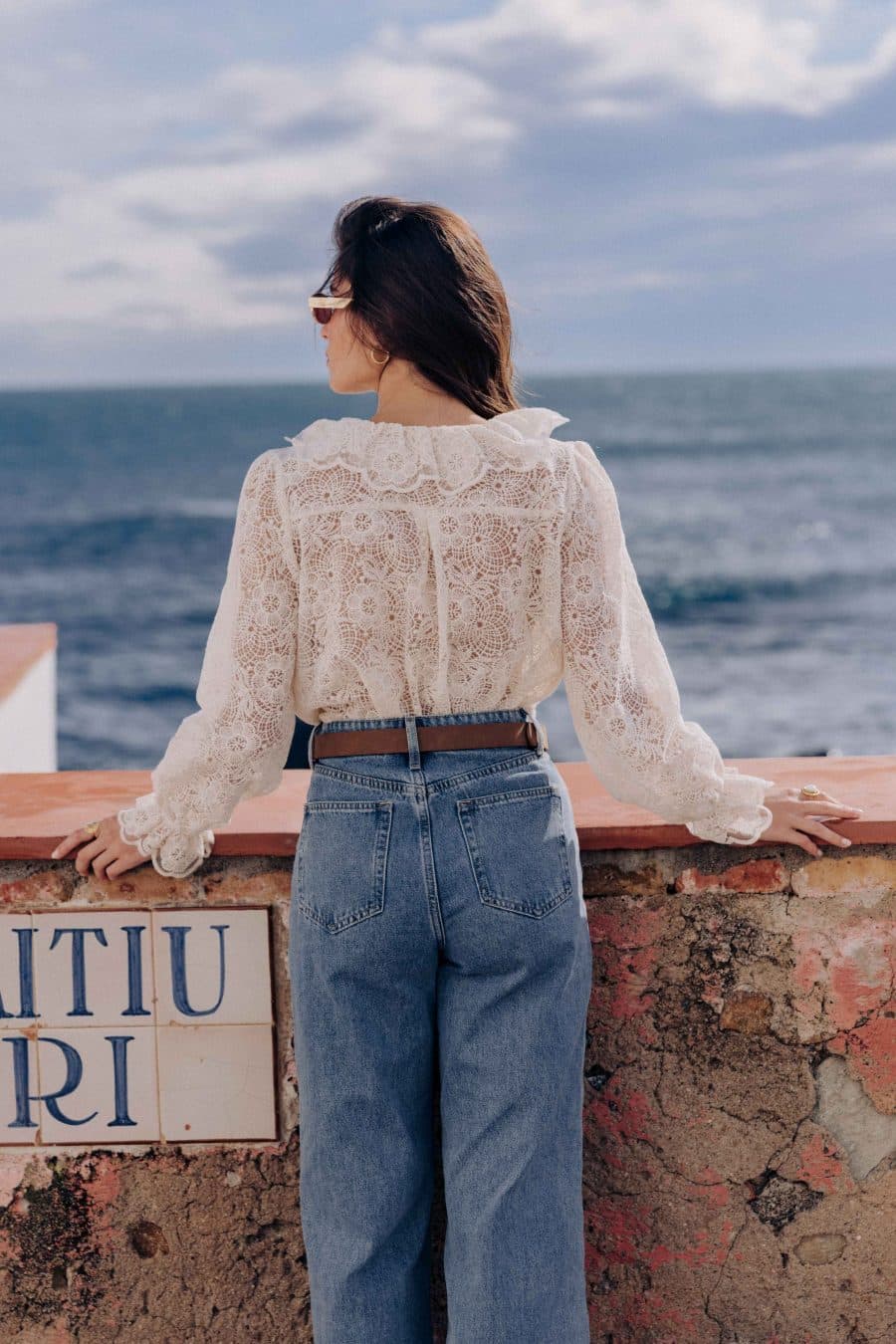 Chemise Clea Sahoma écrue aux motifs floraux en dentelle, col Claudine en dentelle, manches longues, portée avec un jean bleu foncé
