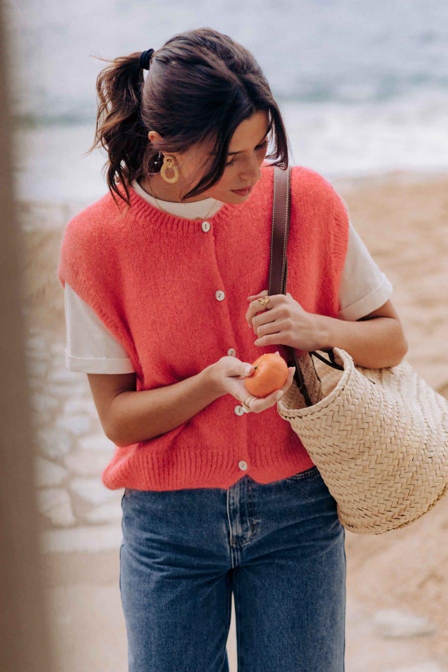 Gilet Margarida Sahoma corail uni, sans manches, portée avec un jean bleu foncé