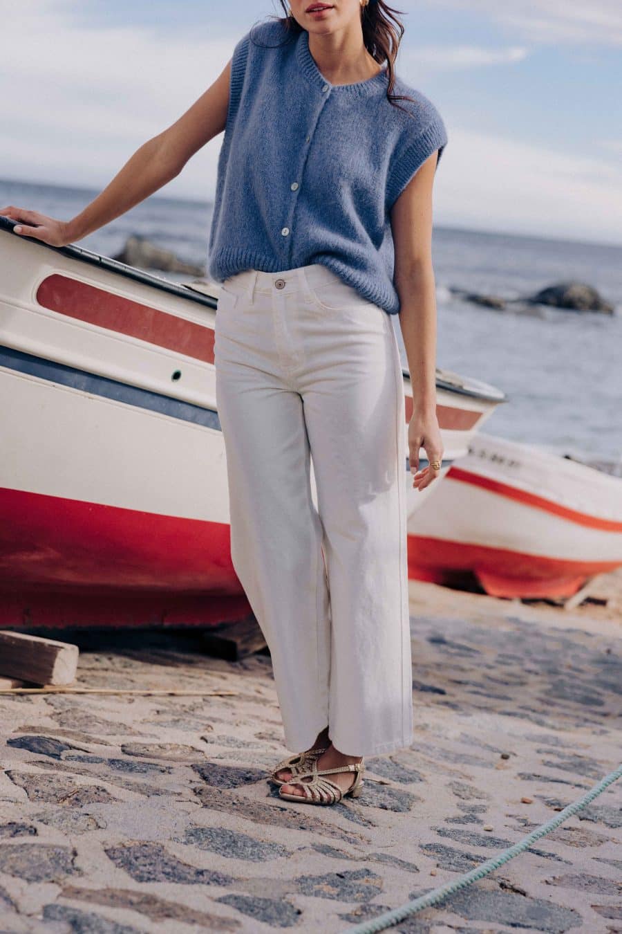 Jean Omar Sahoma blanc, taille haute et coupe courte, porté avec un gilet sans manches bleu