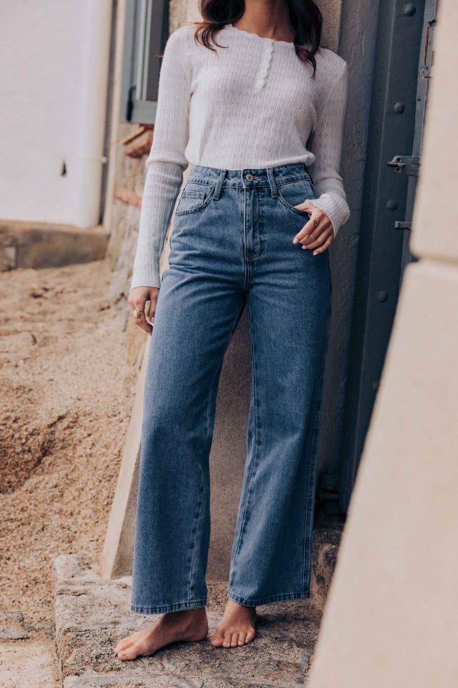 Jean Omar Sahoma bleu vintage, taille haute et coupe courte, porté avec un top en maille blanc