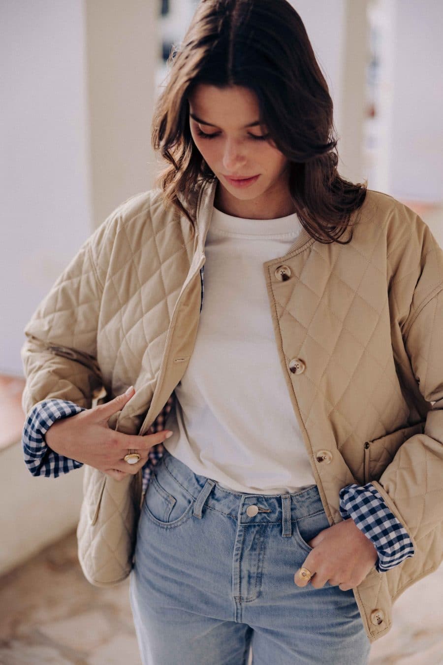 Veste matelassée Calella Sahoma beige uni, col rond, manches longues, doublure vichy bleu, portée avec un jean bleu clair