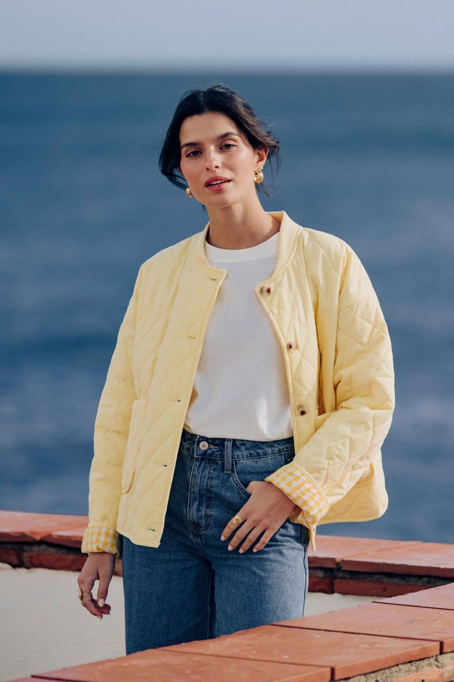 Veste matelassée Calella Sahoma jaune uni, col rond, manches longues, doublure vichy assortie, portée avec un jean bleu