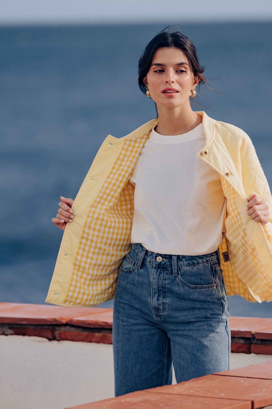 Veste matelassée Calella Sahoma jaune uni, col rond, manches longues, doublure vichy assortie, portée avec un jean bleu