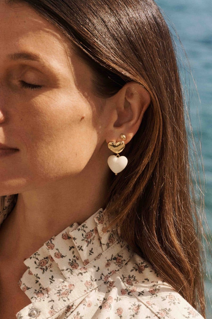 Boucles d'oreilles Maeva Sahoma dorées ornée d'un pendentif forme coeur blanc