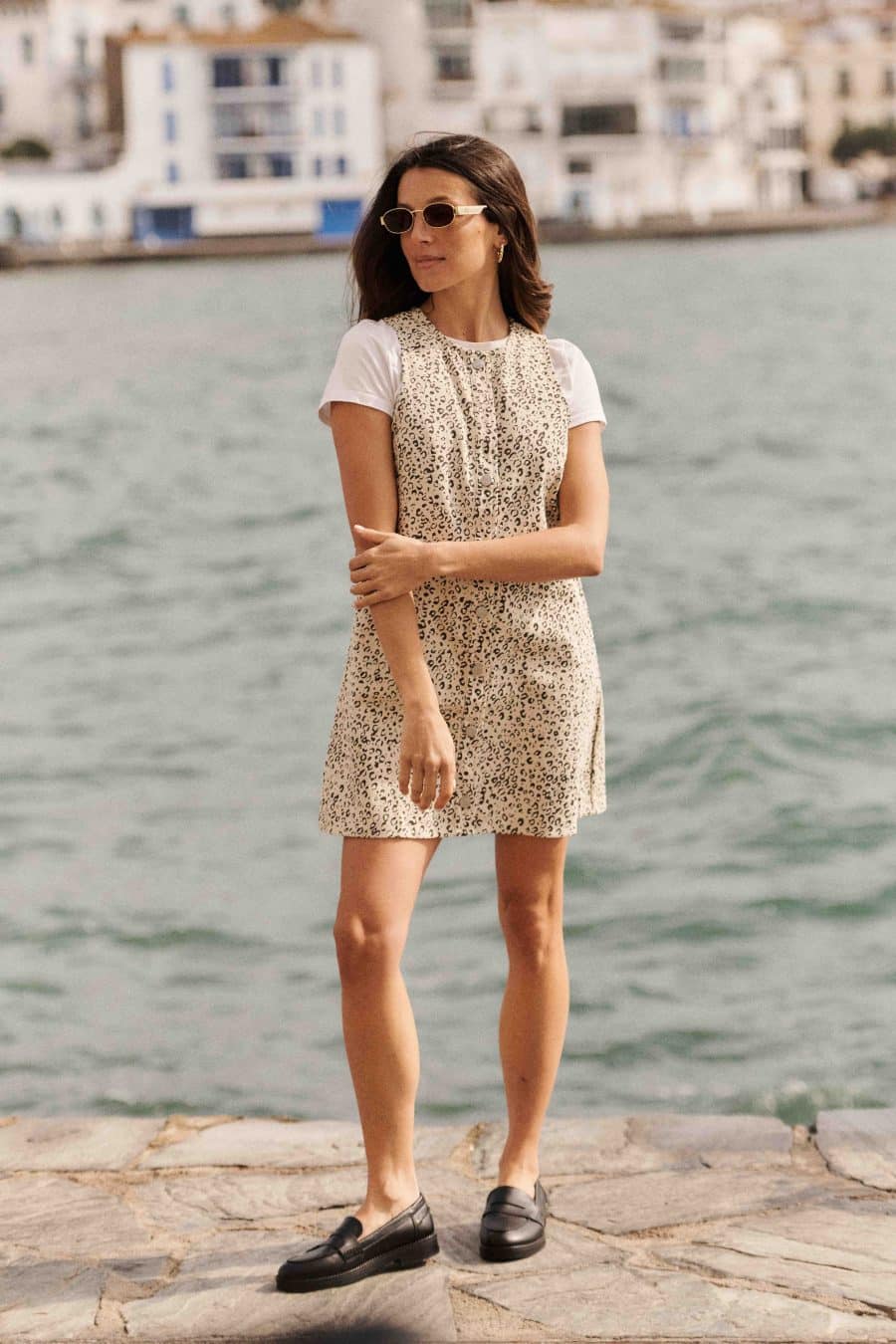 Robe chasuble en jean léopard Prisca Sahoma courte à col rond, portée sur un t-shirt blanc