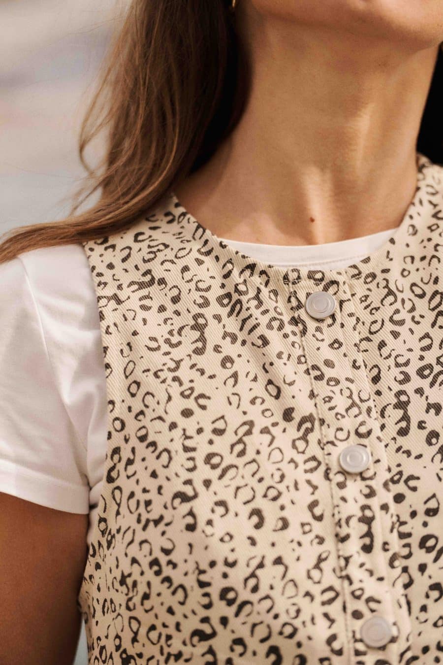 Robe chasuble en jean léopard Prisca Sahoma courte à col rond, portée sur un t-shirt blanc