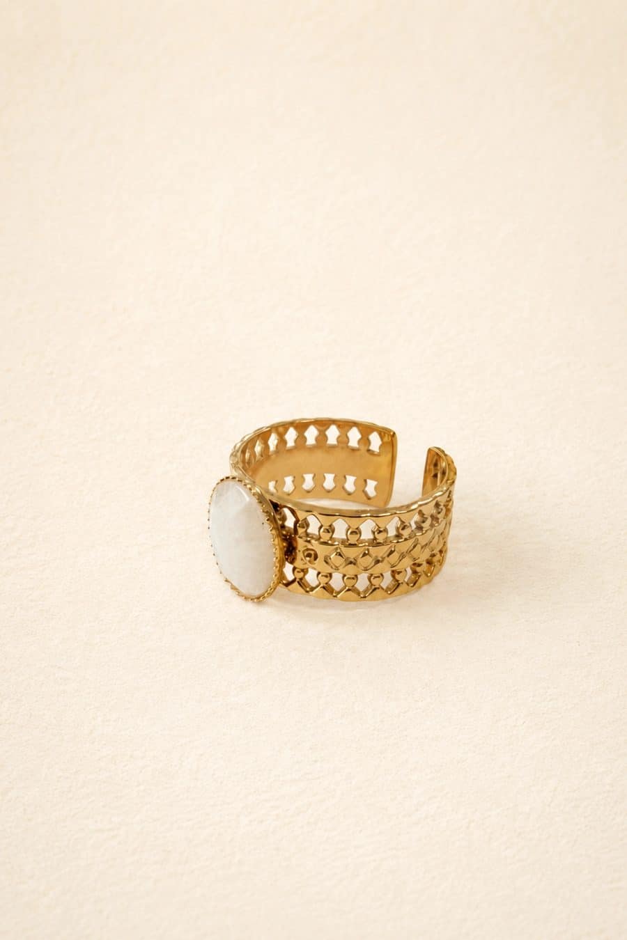 Bague dorée à anneau ajouré, design vintage minimaliste et ornée d'une pierre blanche effet quartz