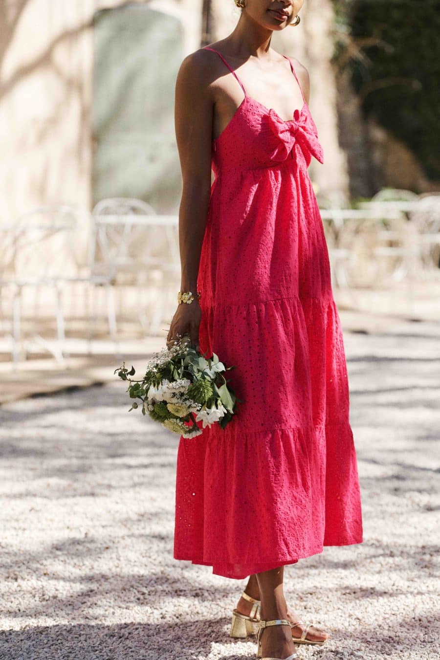 Robe rose fuchsia, coupe longue finition volants, sans manches et fines bretelles bouffantes, noeud à nouer sur la poitrine - laçage dans le dos broderie anglaise ton sur ton