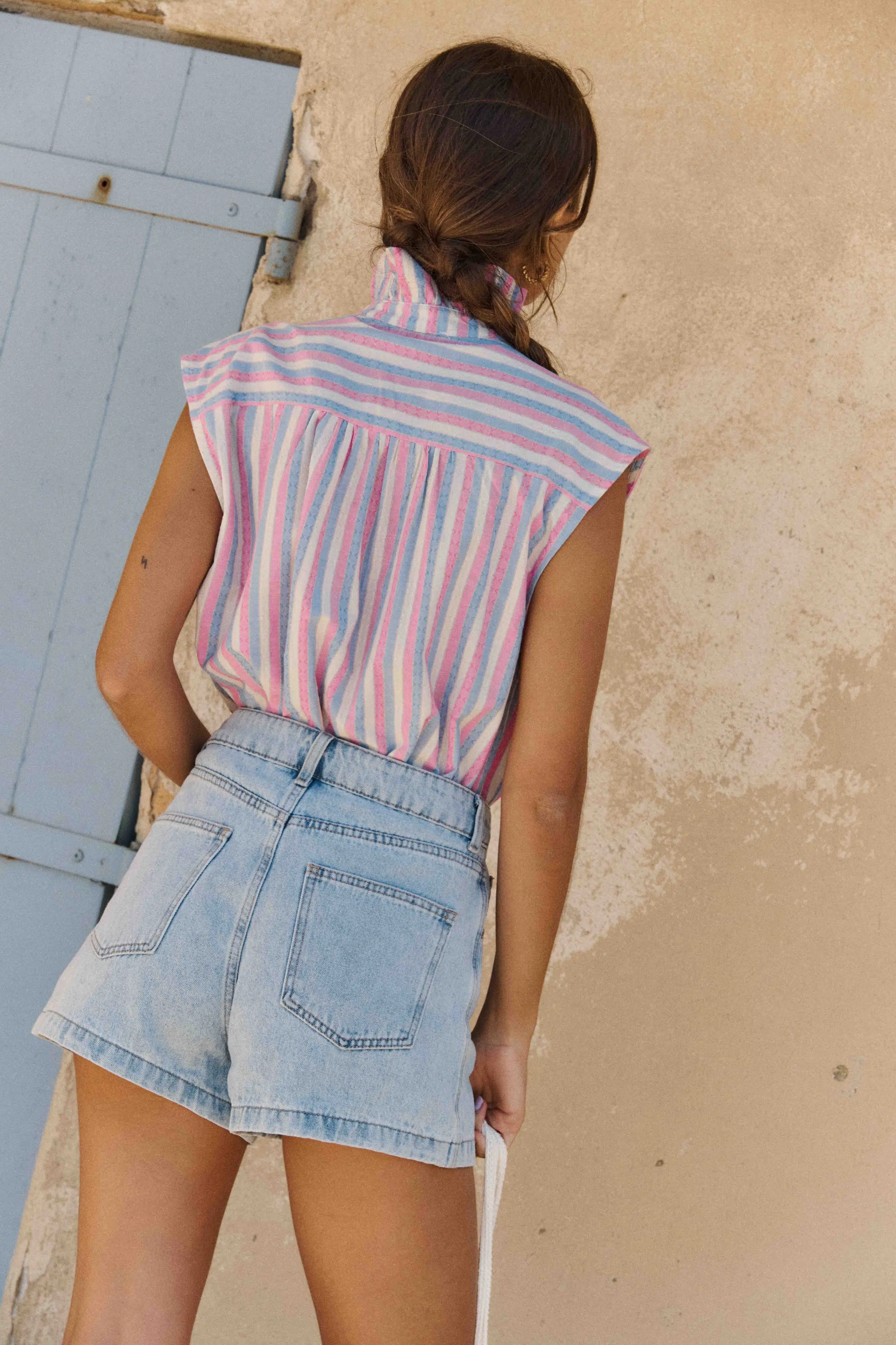 chemise-elora-sans-manches-sahoma-00004 Chemise Elora Sahoma rayée bleu, blanc et rose, sans manches, portée avec un jean bleu foncé