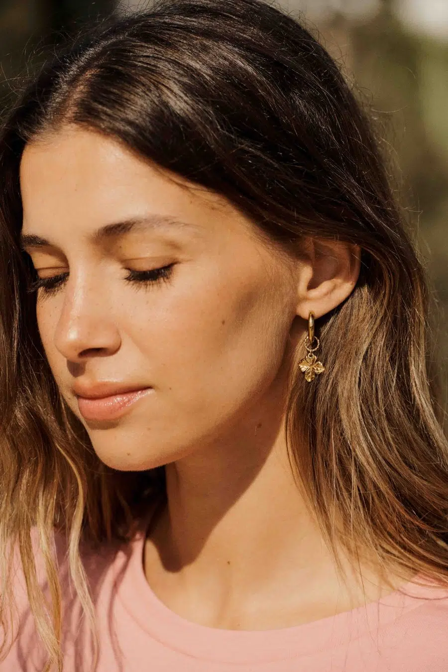 Boucles d'oreilles dorées pendantes forme fleur et oreilles percées