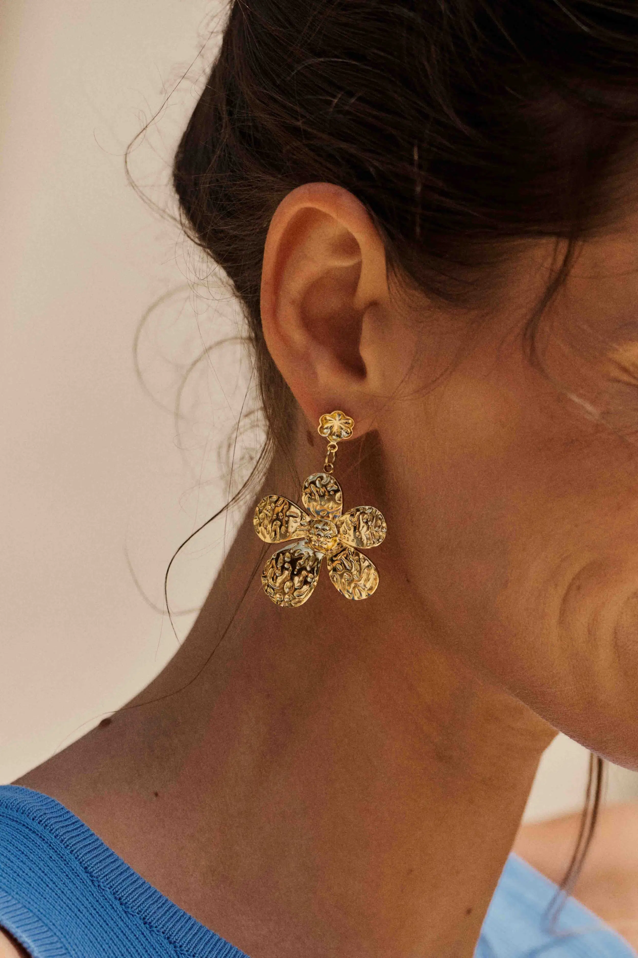 Boucles d'oreilles dorées pendantes forme fleur et oreilles percées