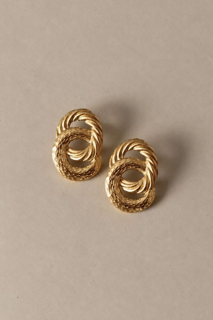 Boucles d’oreilles dorées entrelacées effet strié | bijou sculptural aux courbes travaillées et lumineuses | Sahoma